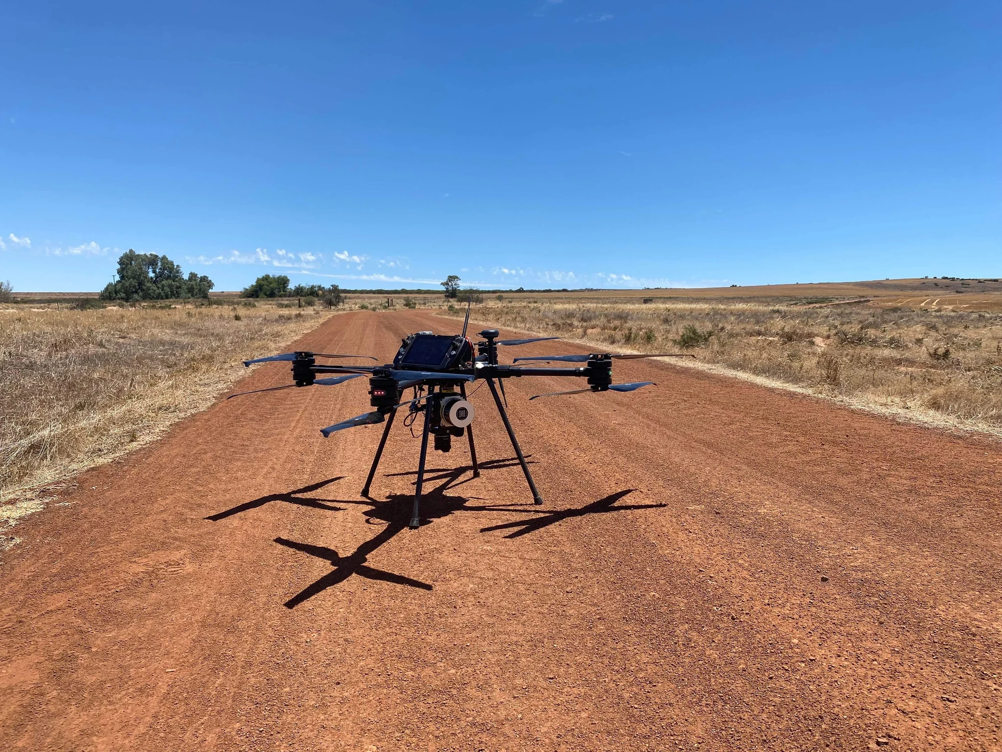 Surveyor 32 LiDAR system mounted beneath a UAV on a remote field road